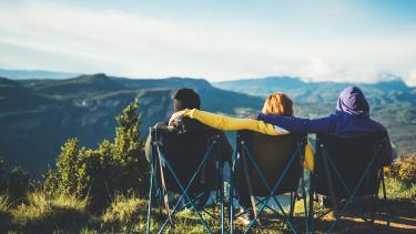 World Mental Health Day Three young people sit in camping chairs looking out onto a mountain vista